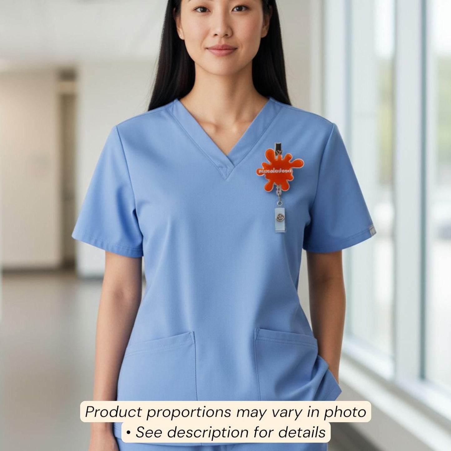 A woman wearing a blue medical uniform with a cartoon character badge on the left side of her chest.