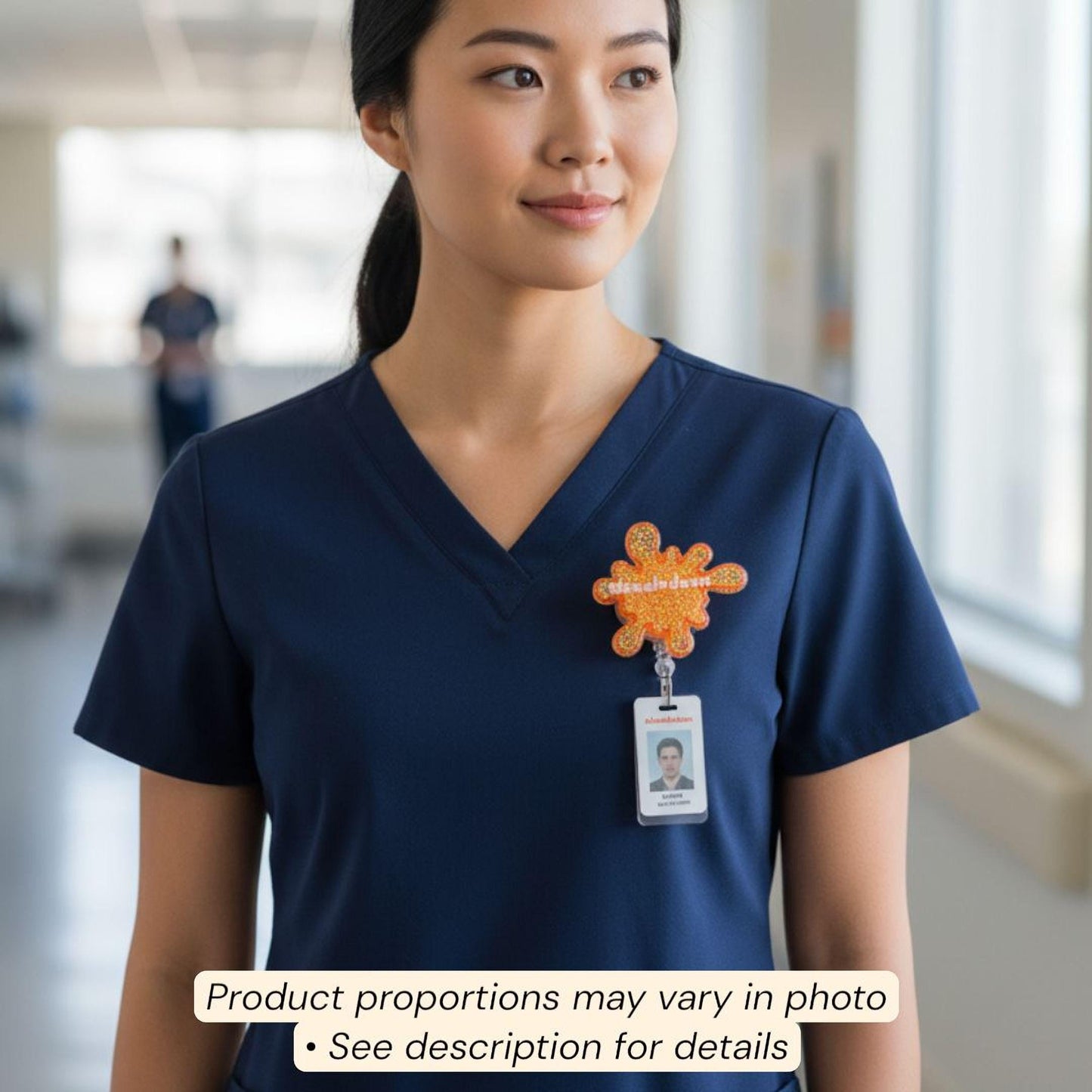 A woman wearing a blue nursing uniform with an orange and orange splash-shaped badge on her left side.