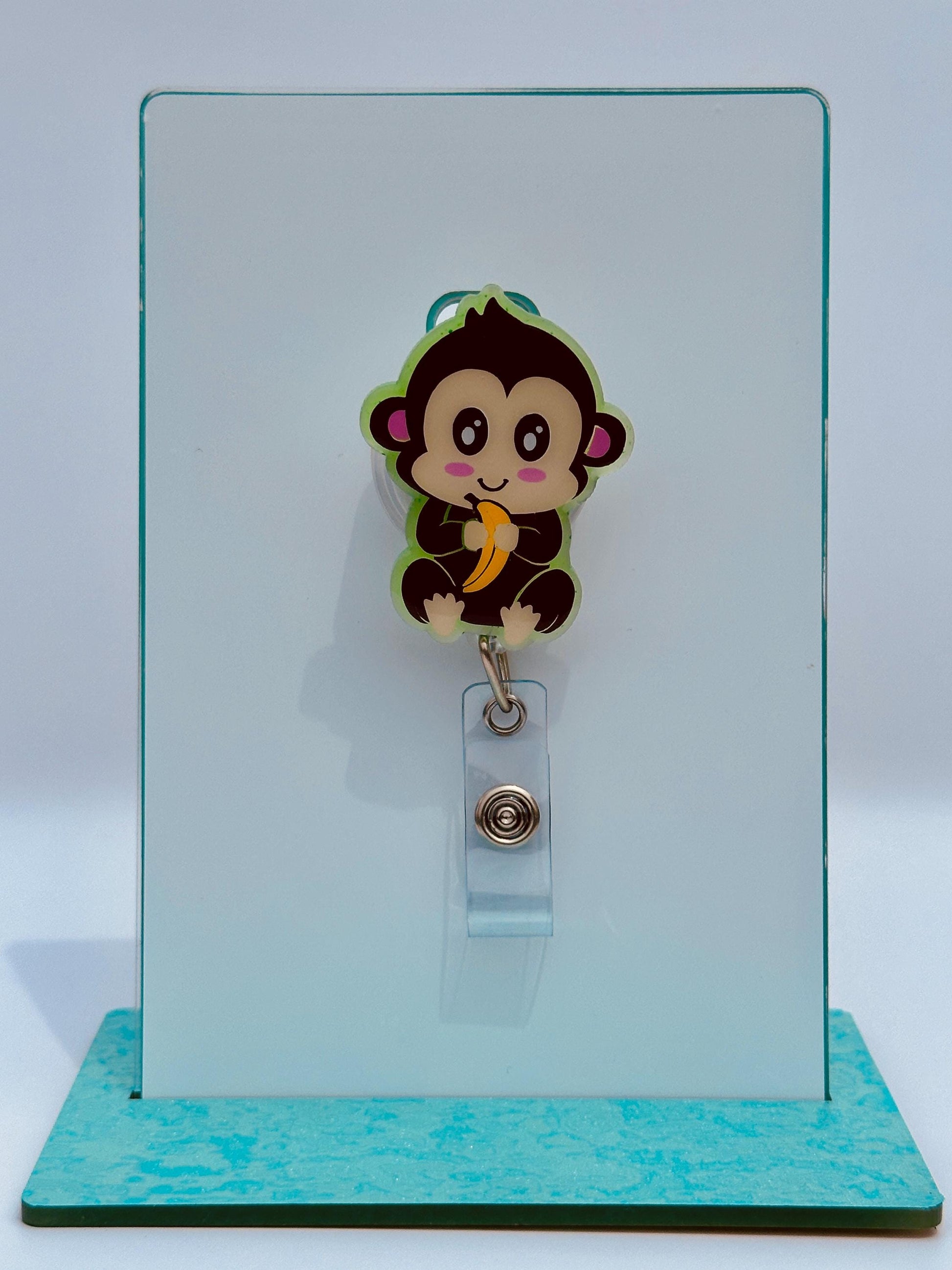 A cartoon monkey wearing a badge with a banana on it is displayed on a white background.