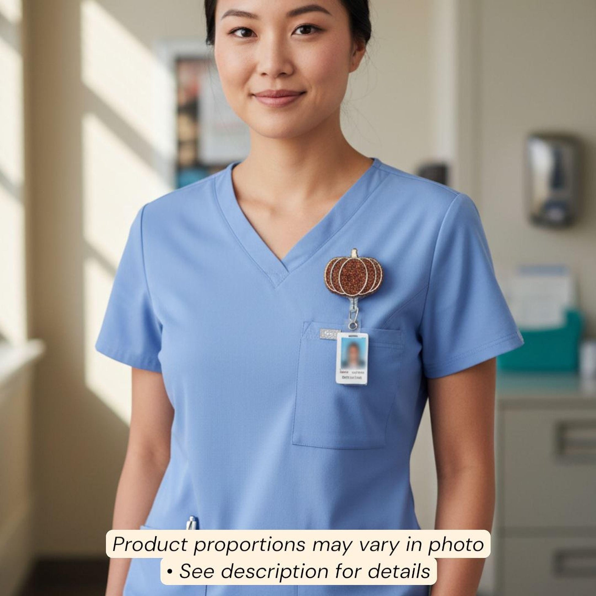 A woman wearing a blue medical uniform with a pumpkin-shaped badge on her shirt.