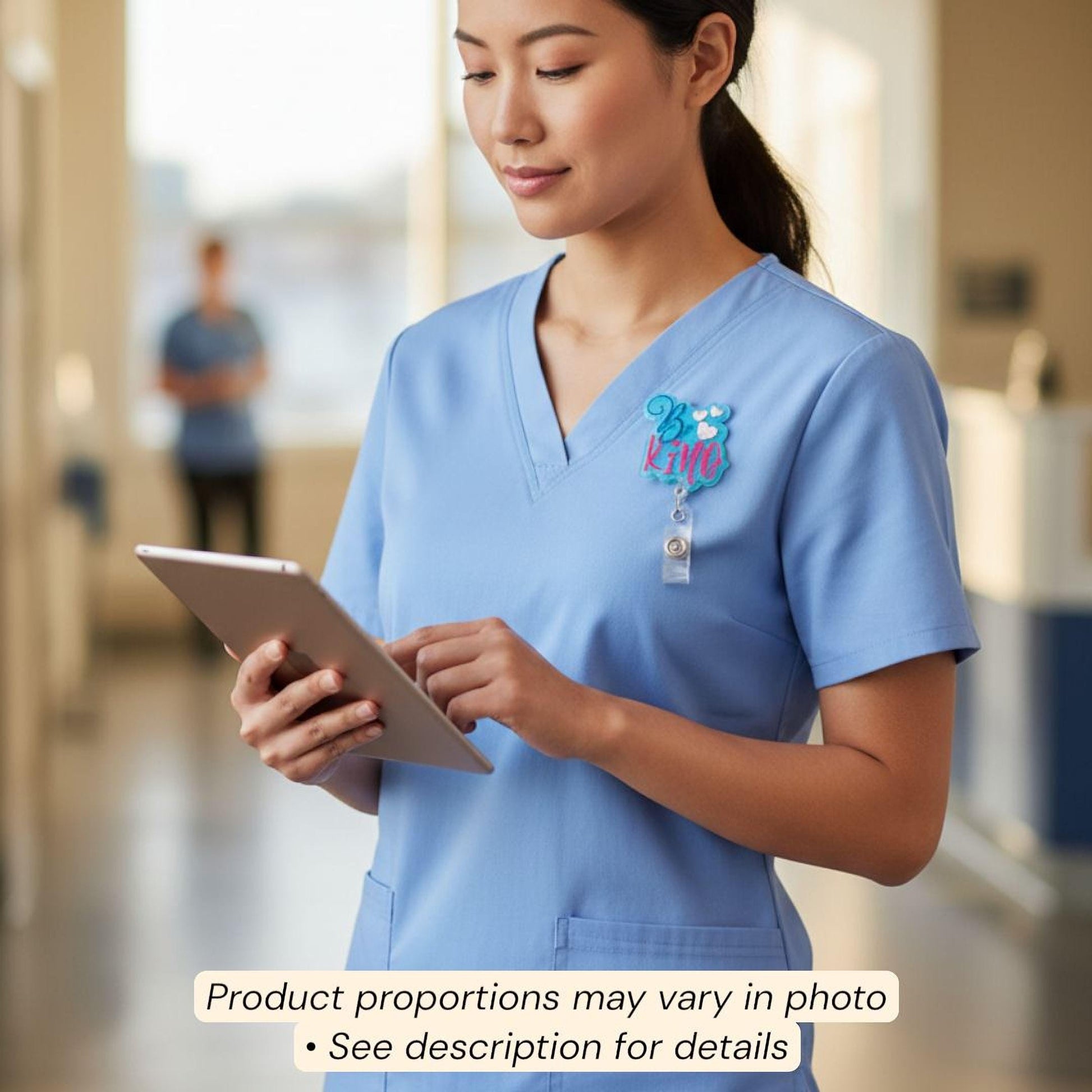 A woman in a blue medical uniform is using a tablet computer in a room with other people in the background.