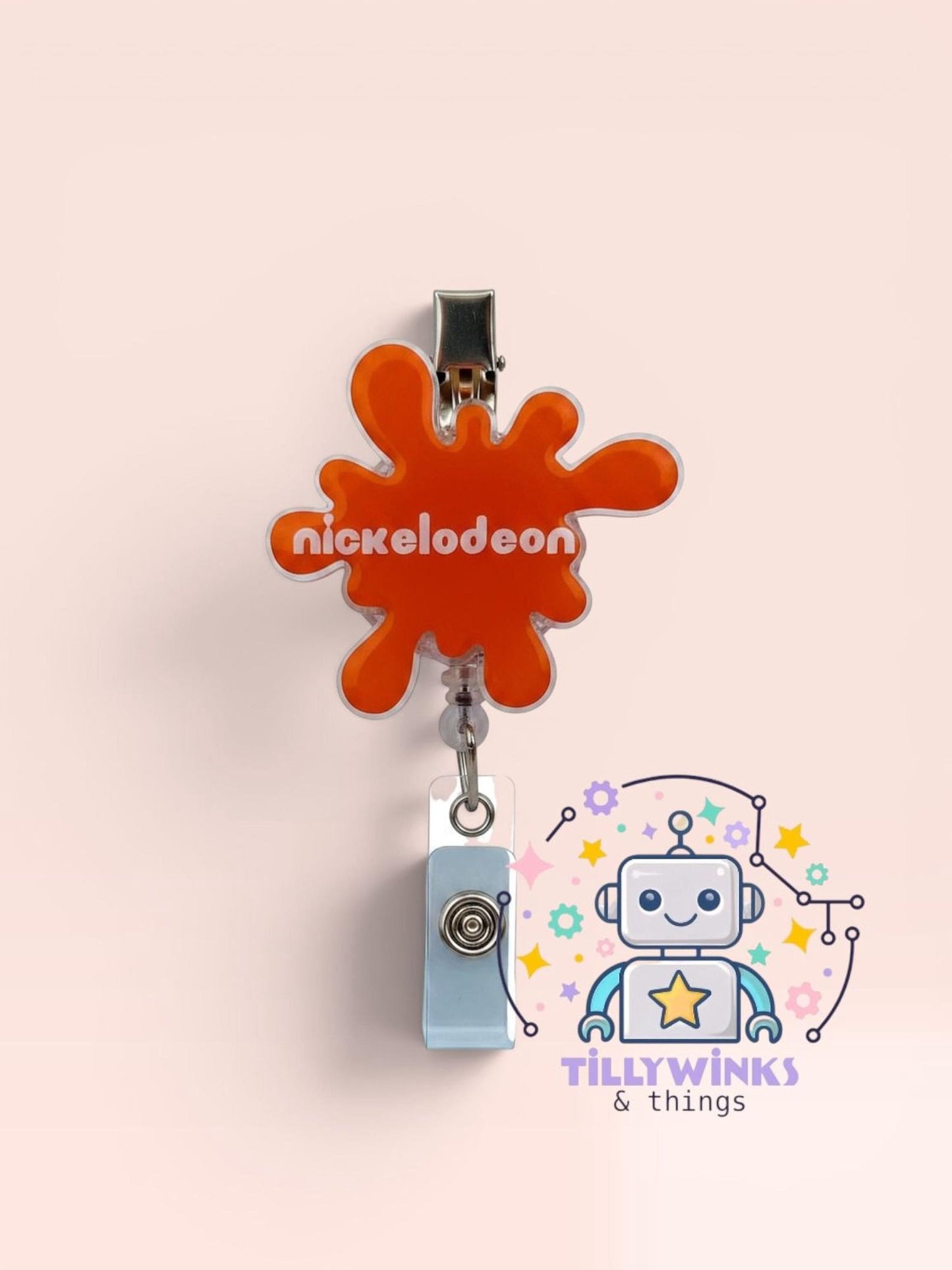 a bright orange splash-shaped badge with the word " Nickelodeon" written on it, hanging on a wall. Below the badge, there is a small robot-like character with a star on its head, surrounded by various colorful elements.