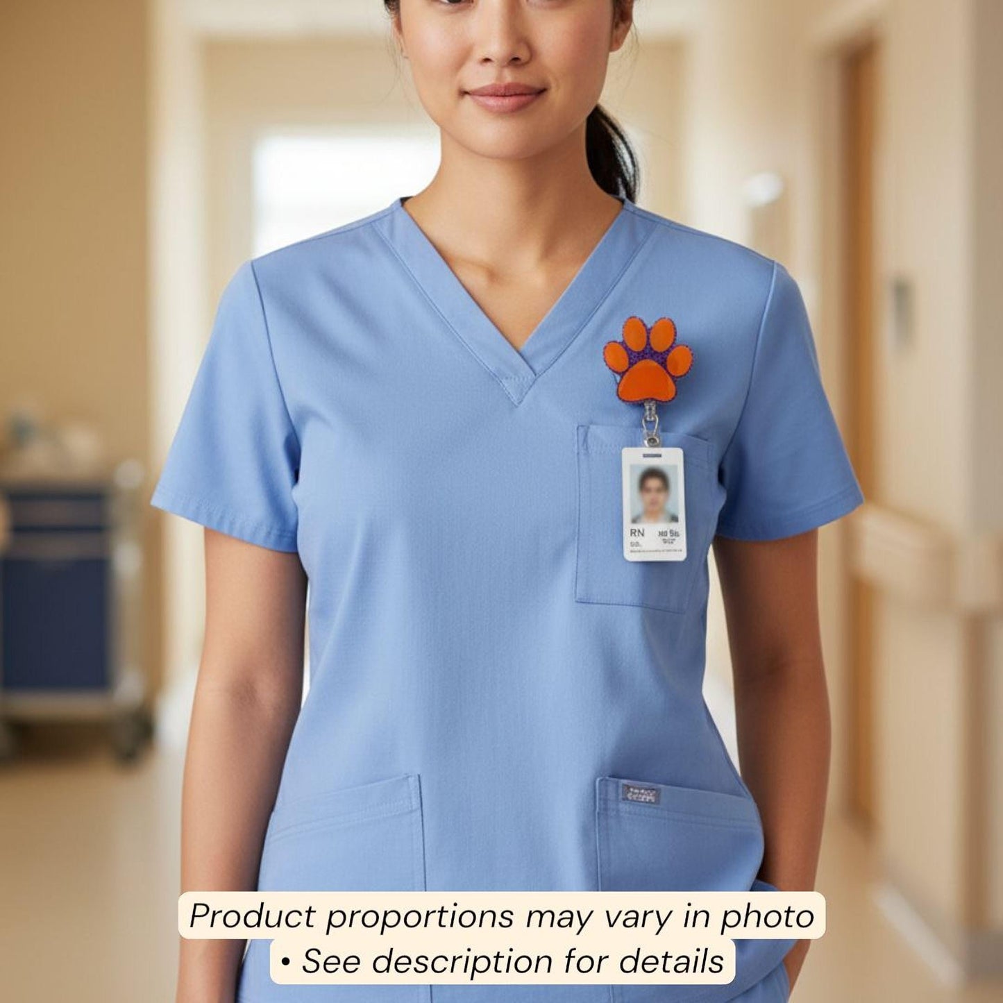 A woman wearing blue medical scrubs with a paw print badge on the left side of her chest.