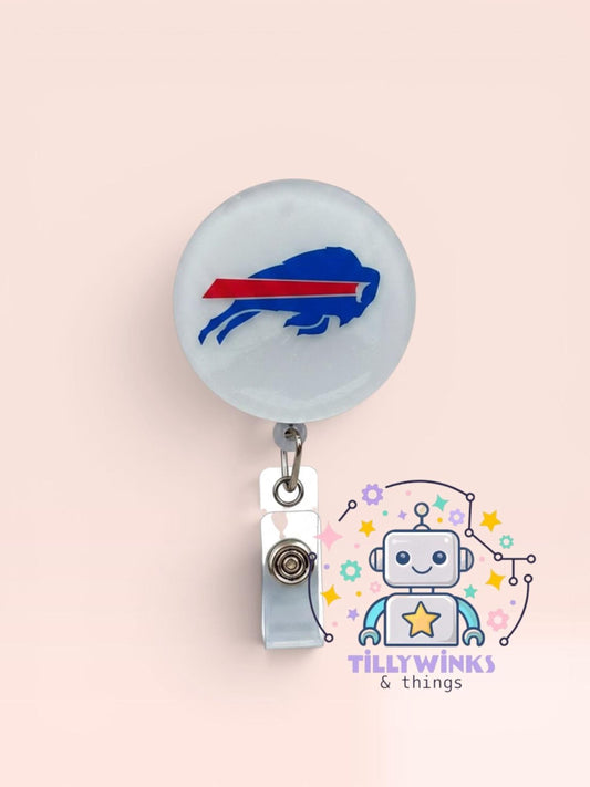 a badge with a buffalo buffalo logo on it, hanging from a clip. Below the badge, there is a cartoon robot with a star and a smiley face.