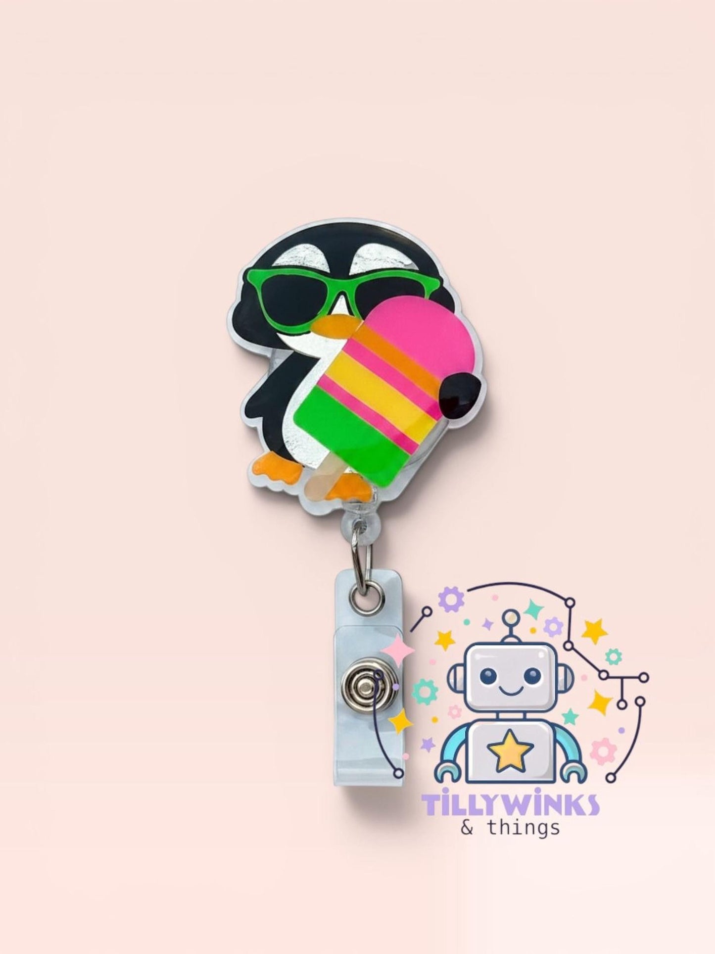 A colorful penguin-shaped badge holder with a popsicle-shaped handle, featuring a robot-like character and a "Tillywinks & things" logo.