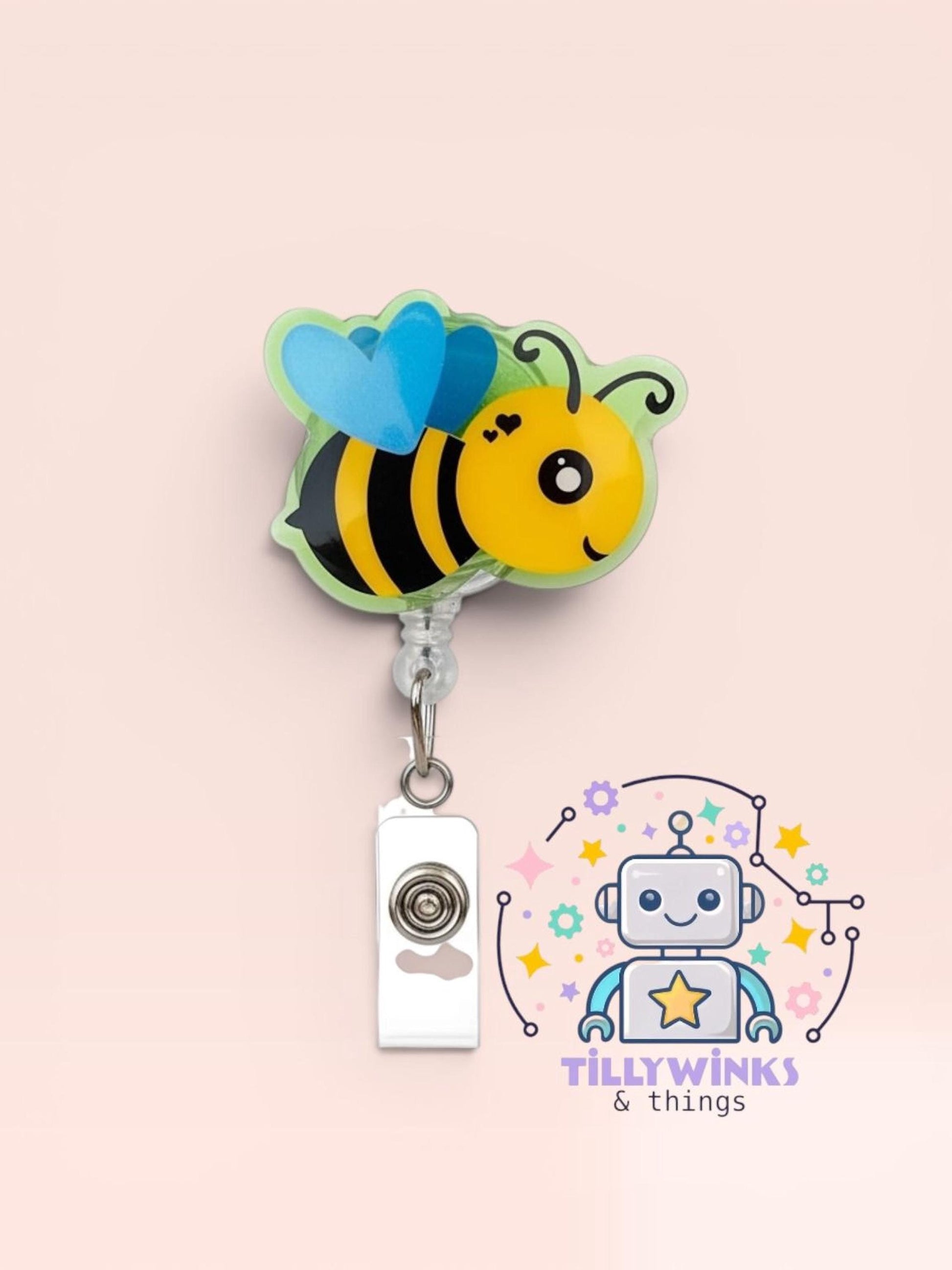 A colorful bee-shaped badge with a heart-shaped wing attached, hanging from a clip.