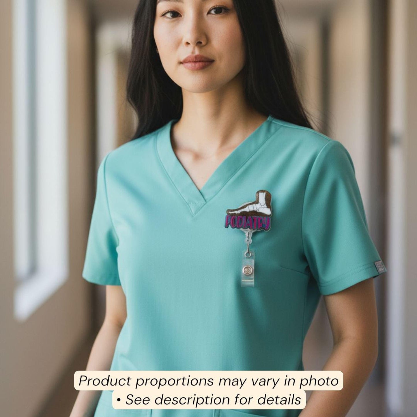 A woman wearing a turquoise medical scrubs top with a badge on the left side of her chest.