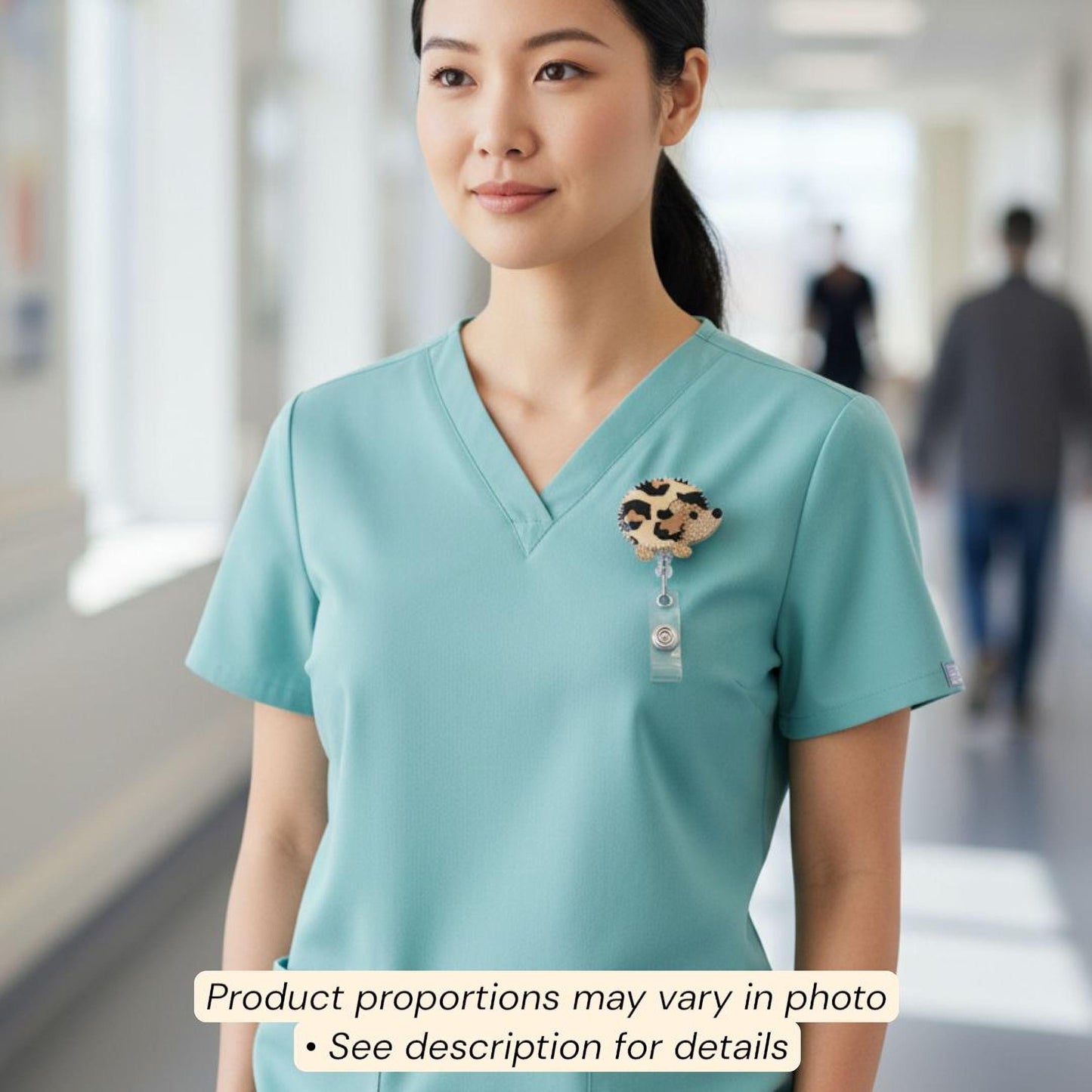 A woman wearing a turquoise medical scrubs top with a leopard print badge hanging from her uniform.
