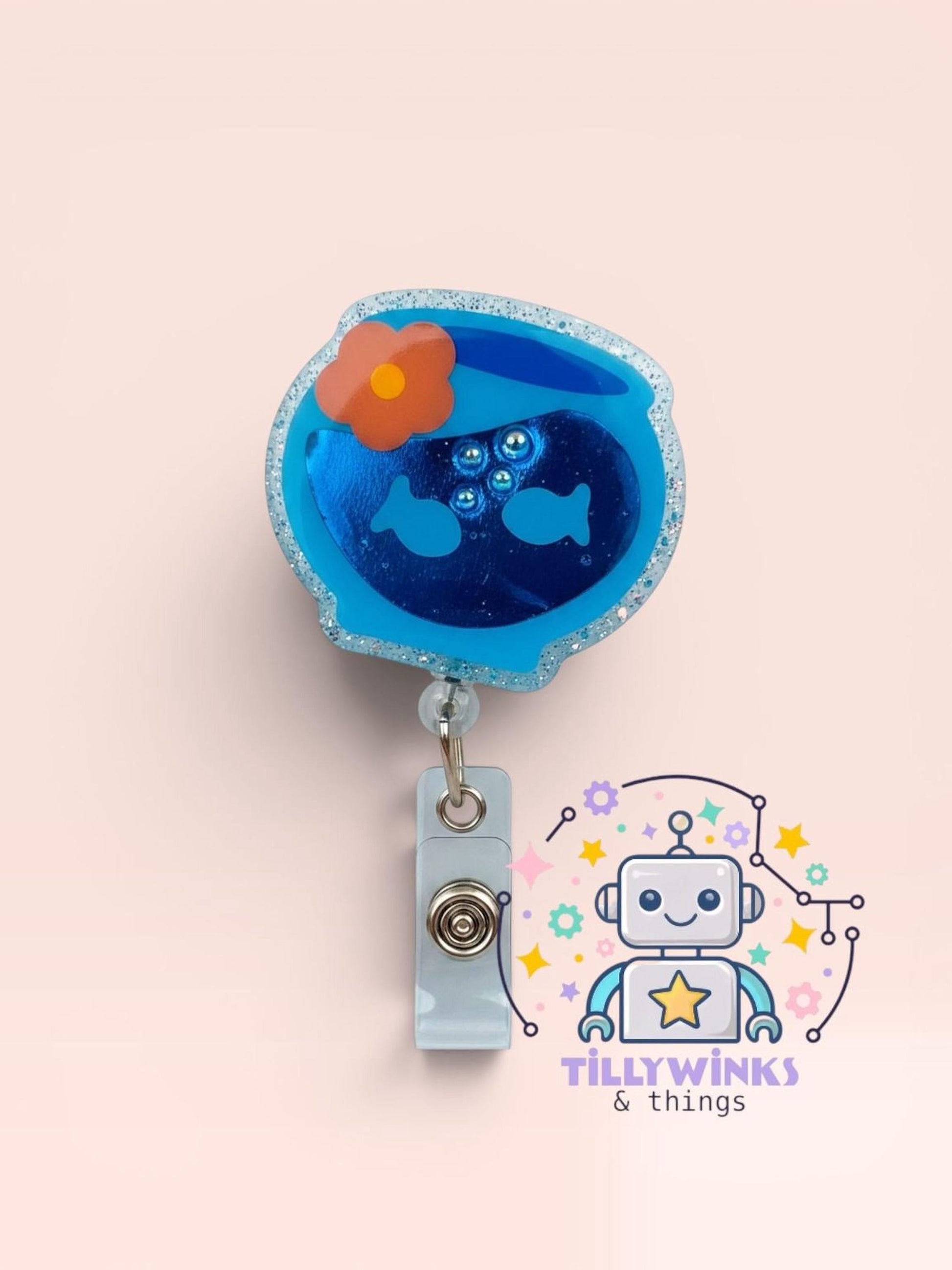 A blue and orange fish-shaped badge with a flower on top, hanging from a gray clip.