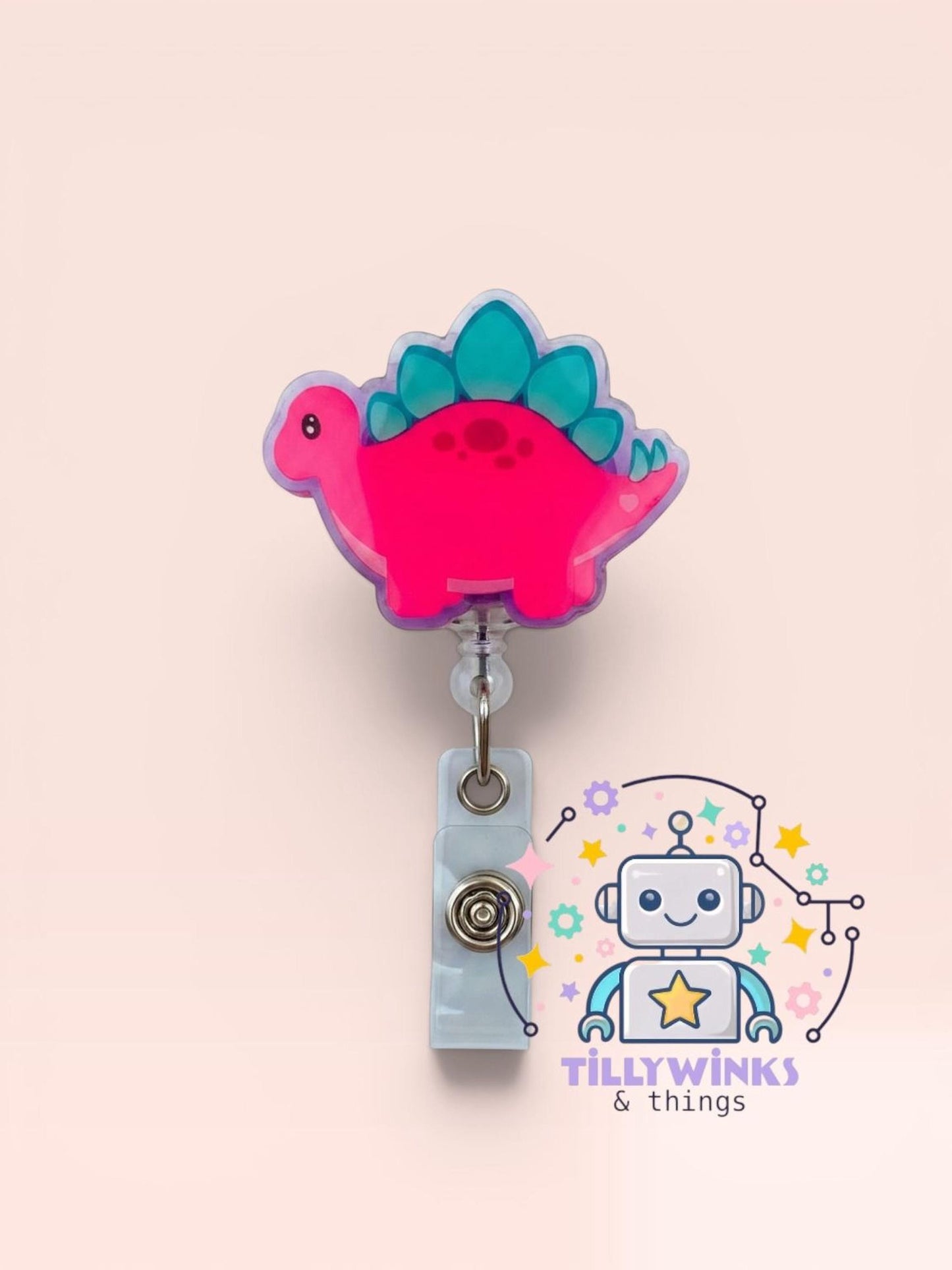 A pink dinosaur-shaped badge with a clear plastic holder attached to it, along with a robot-like character and various colorful elements.